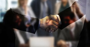 Handshake between two individuals wearing suits